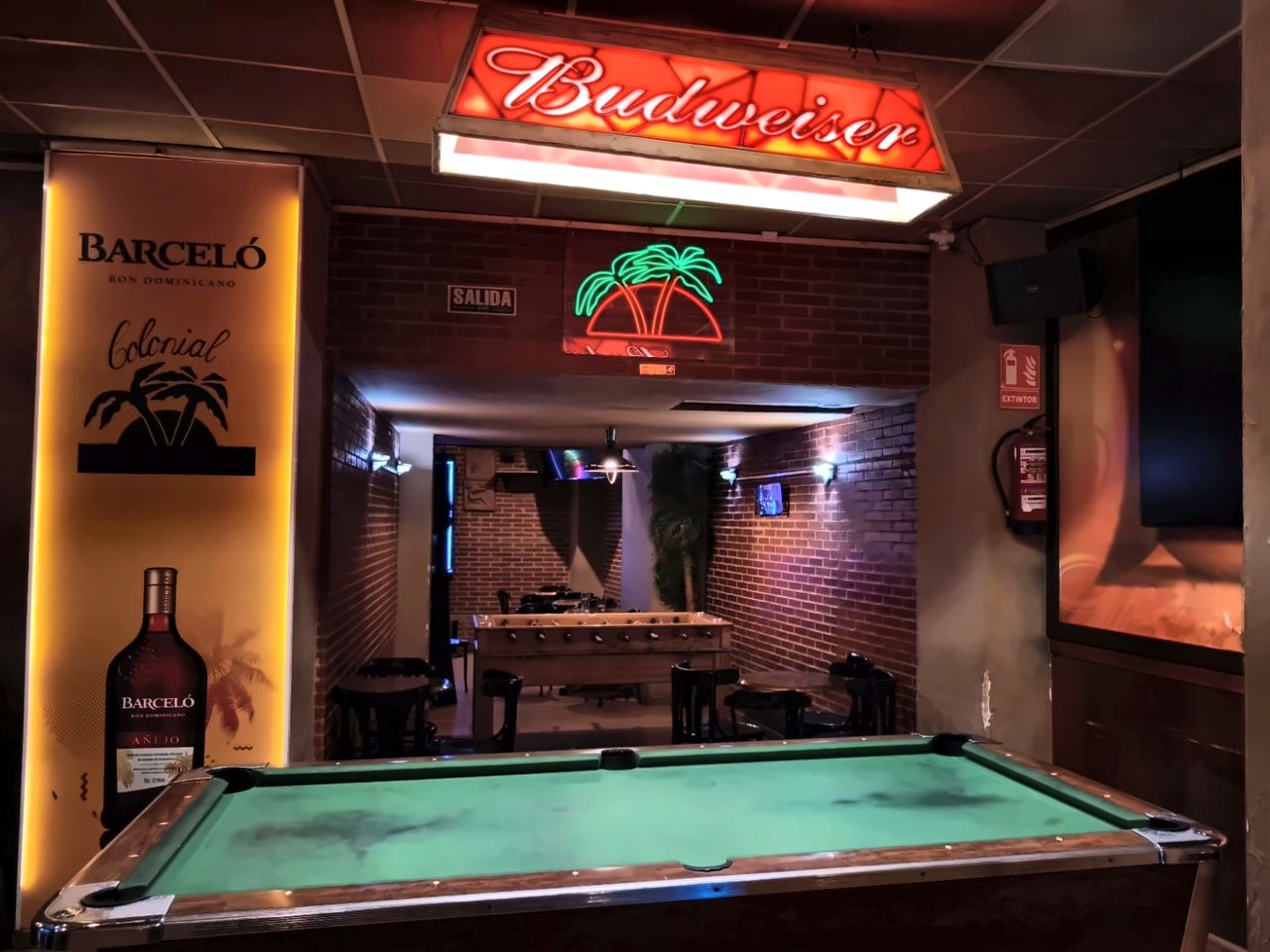 Mesa de billar bajo la lámpara de Budweiser
