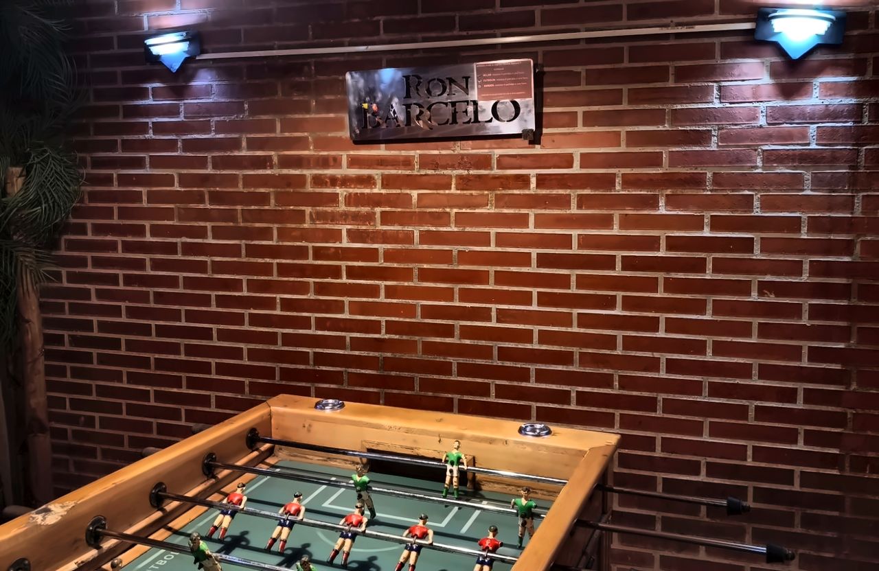 Futbolín de madera en la sala de ladrillo